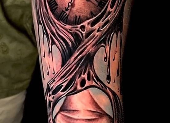 Clock motif with flowing details on a forearm