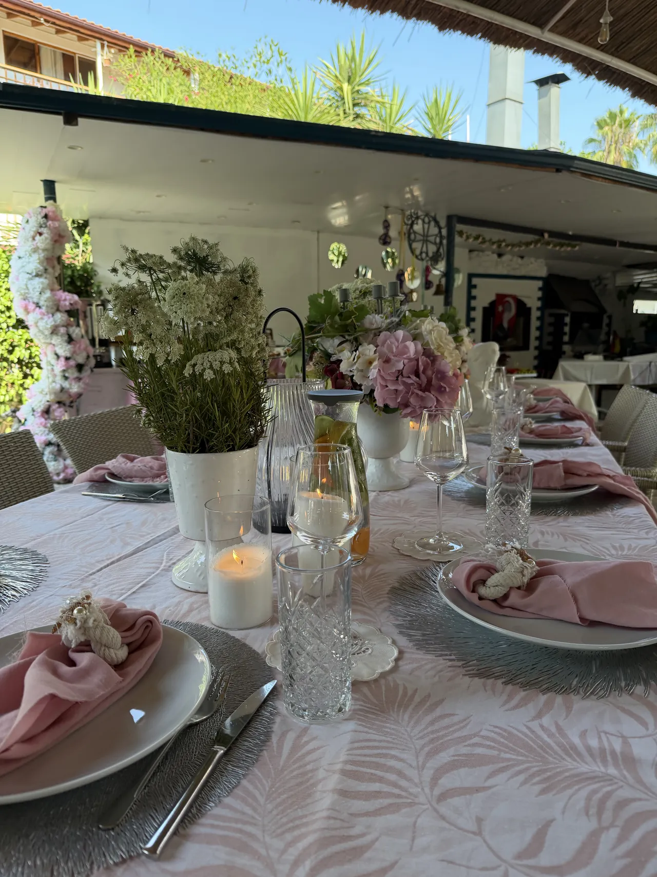 Una tavola in festa con tovaglioli rosa e fiori nel giardino dell’Erendiz.