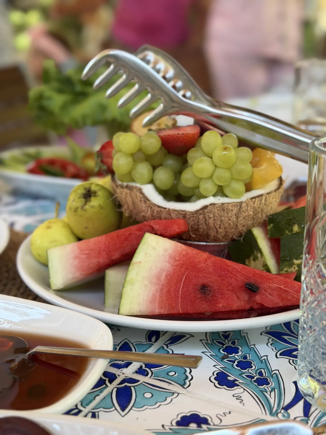 Un vassoio di frutta con anguria, uva e pere.